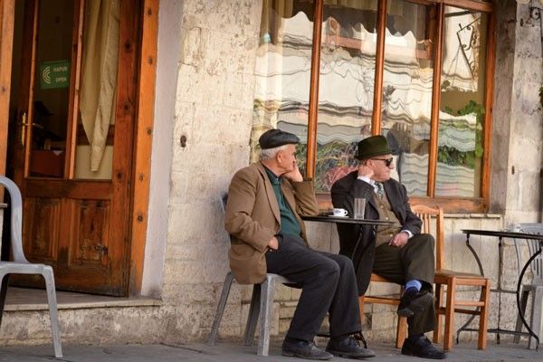 Hombres tomando una bebida en Gjirokastra. © Céline Chaudeau.